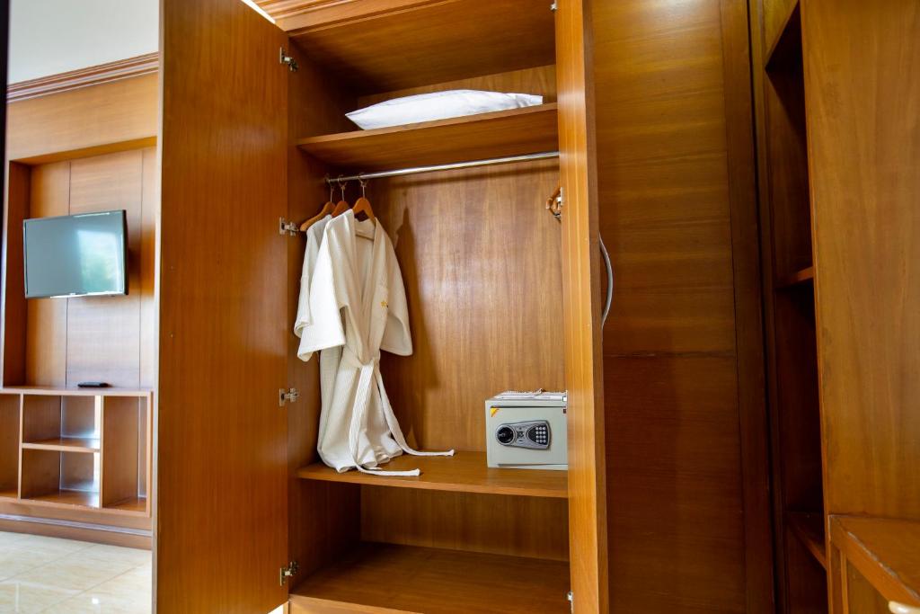 a room with a closet with a microwave and a robe at Sungthong Kamala Beach Resort in Kamala Beach