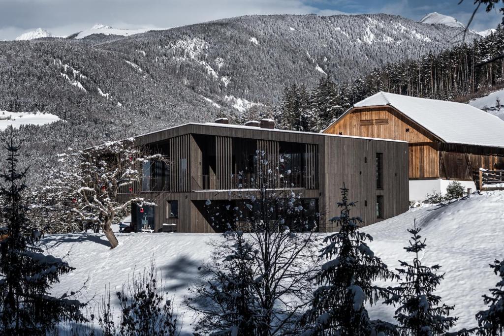 a building in the snow with mountains in the background at naturApart in Brunico