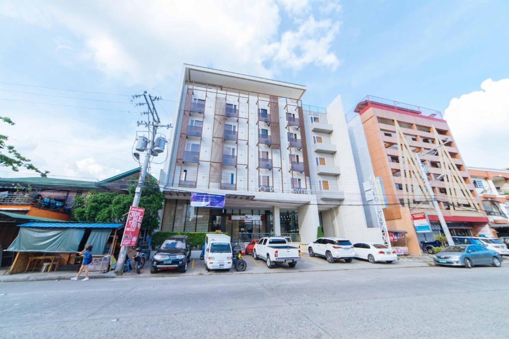 ein großes Gebäude mit davor geparkt in der Unterkunft RedDoorz Plus @ Roxas Street Davao in Davao City