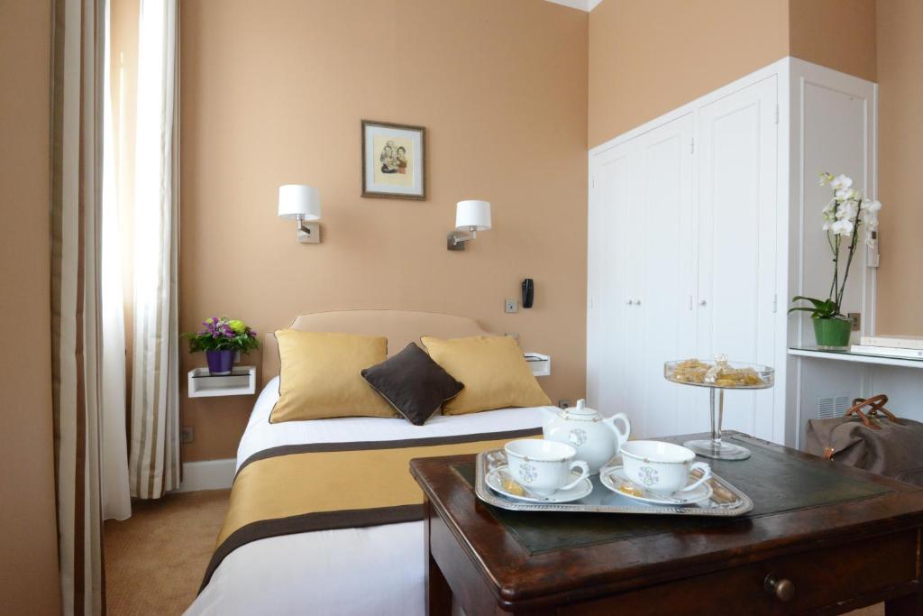a bedroom with a bed and a table with tea cups at Hotel Splendid in Cannes