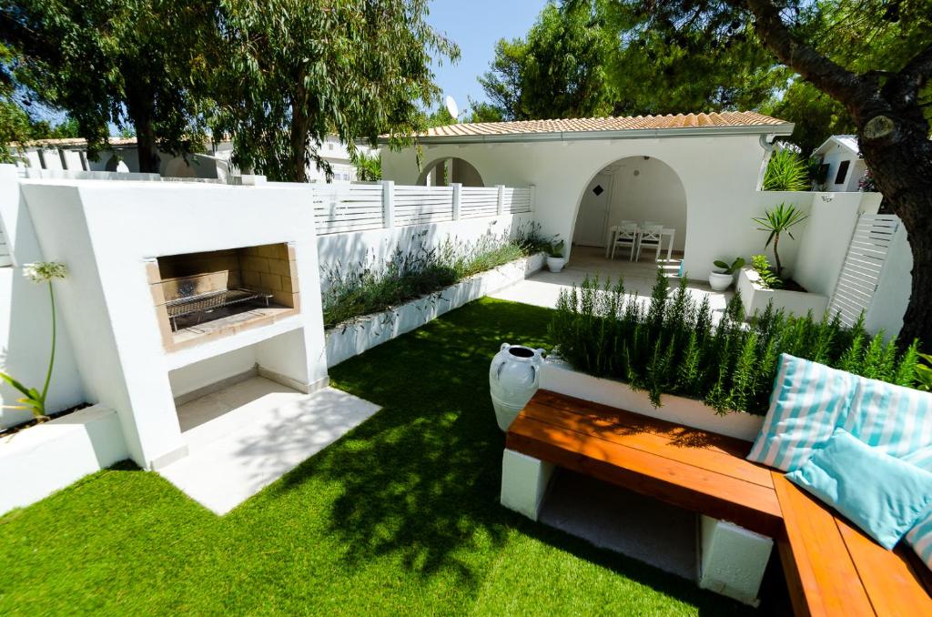 a small backyard with a bench and grass at Malia Village in Vieste