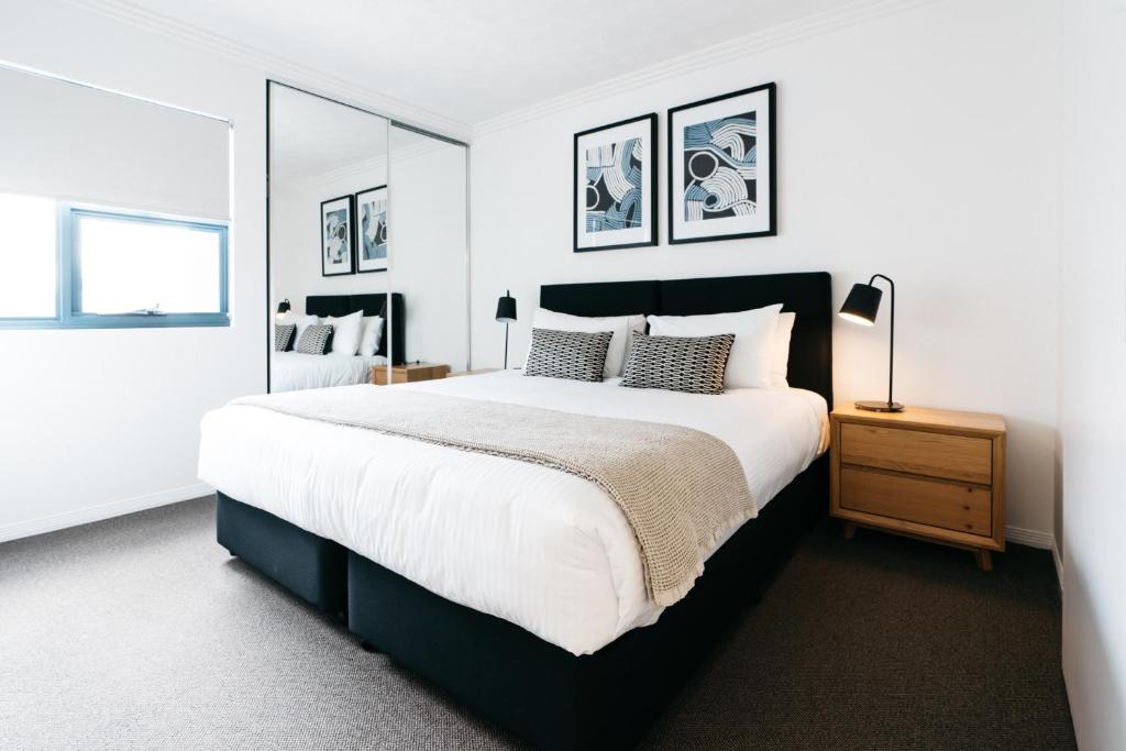 a bedroom with a large bed and a mirror at Gabba Central Apartments in Brisbane