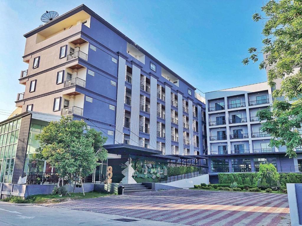 een blauw gebouw met een standbeeld ervoor bij Embryo Hotel  in Pattaya