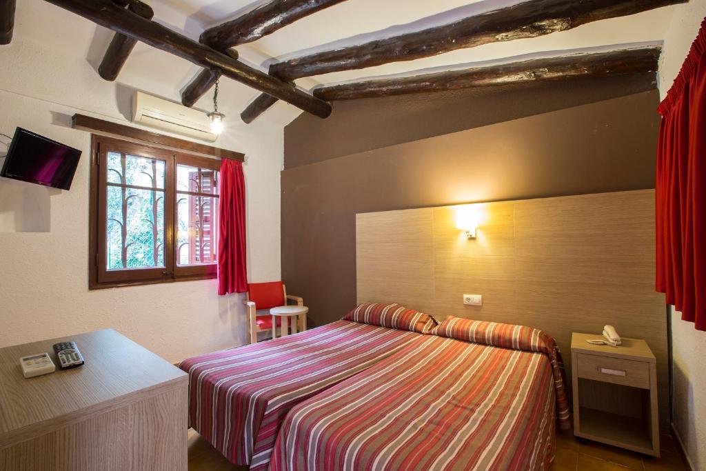 - une chambre avec un lit, un bureau et une fenêtre dans l'établissement Hotel - Bungalows Don Juan Tossa, à Tossa de Mar