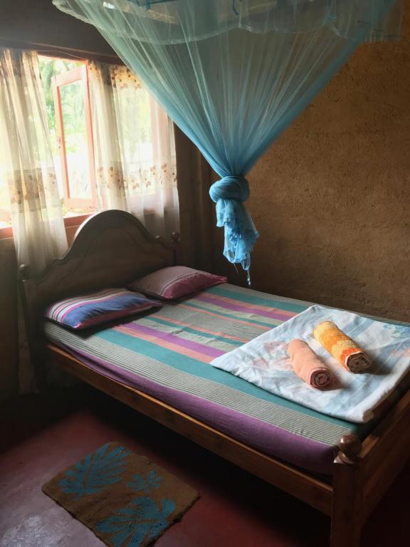 a bed with a canopy with two people on it at Deniyaya National backpackers hostel in Deniyaya