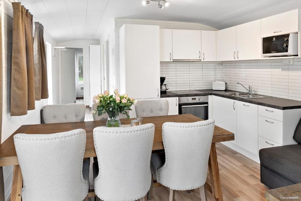 a kitchen and dining room with a wooden table and chairs at First Camp Karlstorp-Halmstad in Halmstad