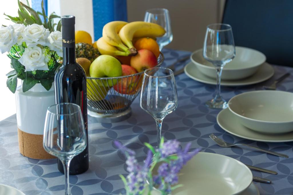 a table with a bowl of fruit and wine glasses at Adriana's Dream View 2 bedrooms apartment in Zadar