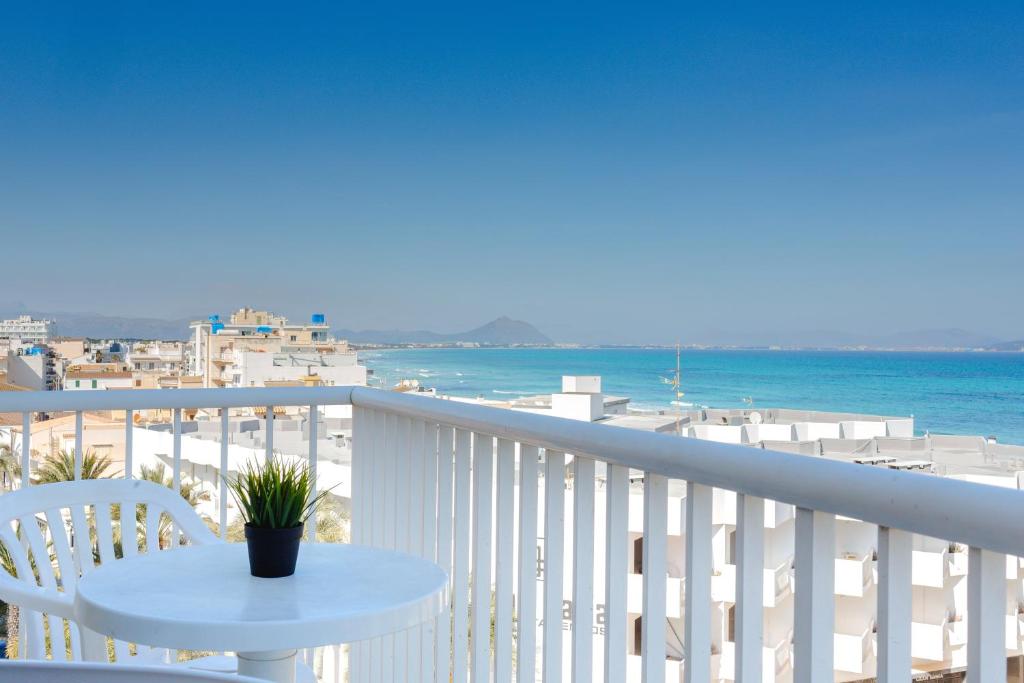 balcone bianco con tavolo e vista sulla spiaggia di Hostal Blanca a Can Picafort