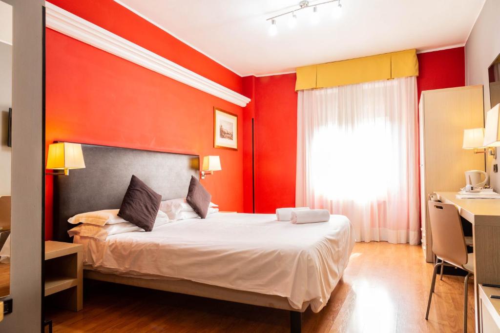 una camera con pareti rosse e gialle e un letto di Hotel Berlino a Milano