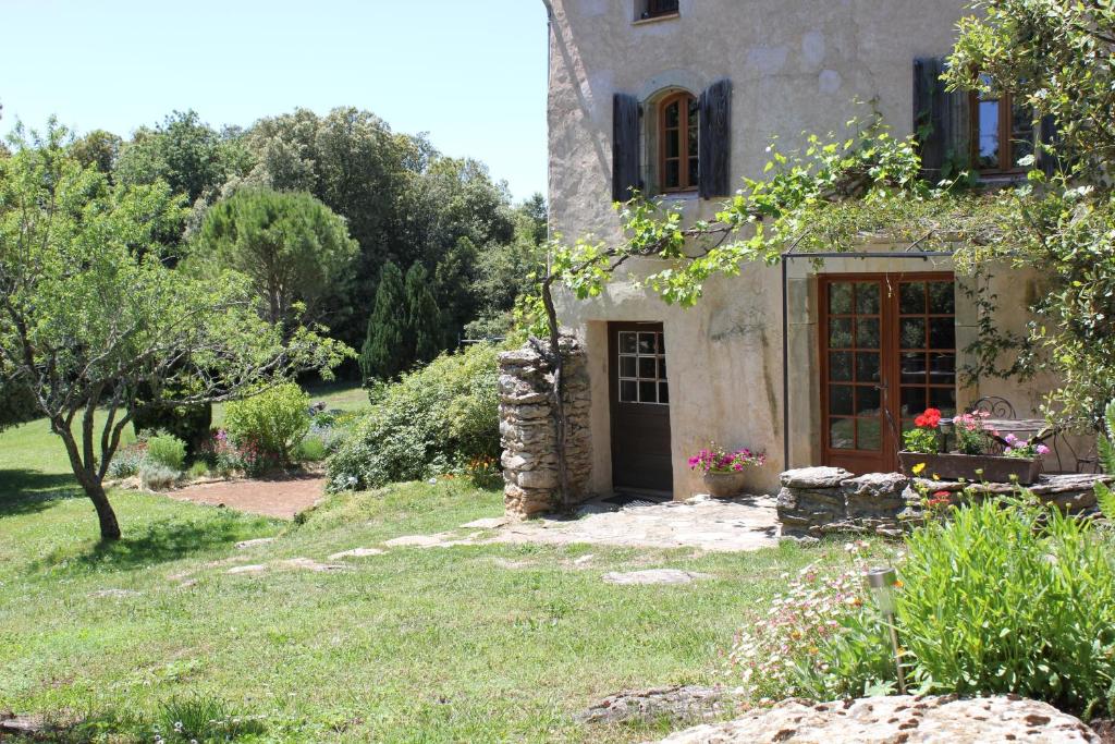 una casa de piedra con una puerta en un patio en Domaine de Perruche du buis en Arques