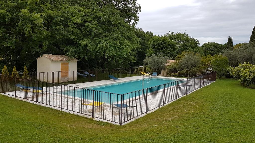 a fence around a swimming pool in a yard at Gîte de charme in Mirabel-aux-Baronnies