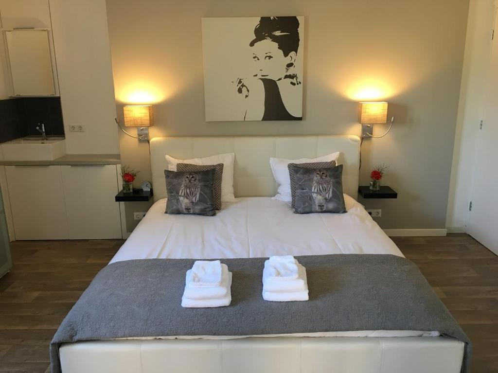 a bedroom with a large white bed with towels on it at La Tulipe in Egmond aan den Hoef
