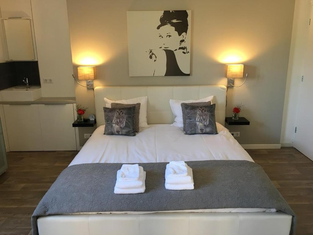 een slaapkamer met een groot wit bed en handdoeken bij La Tulipe in Egmond aan den Hoef