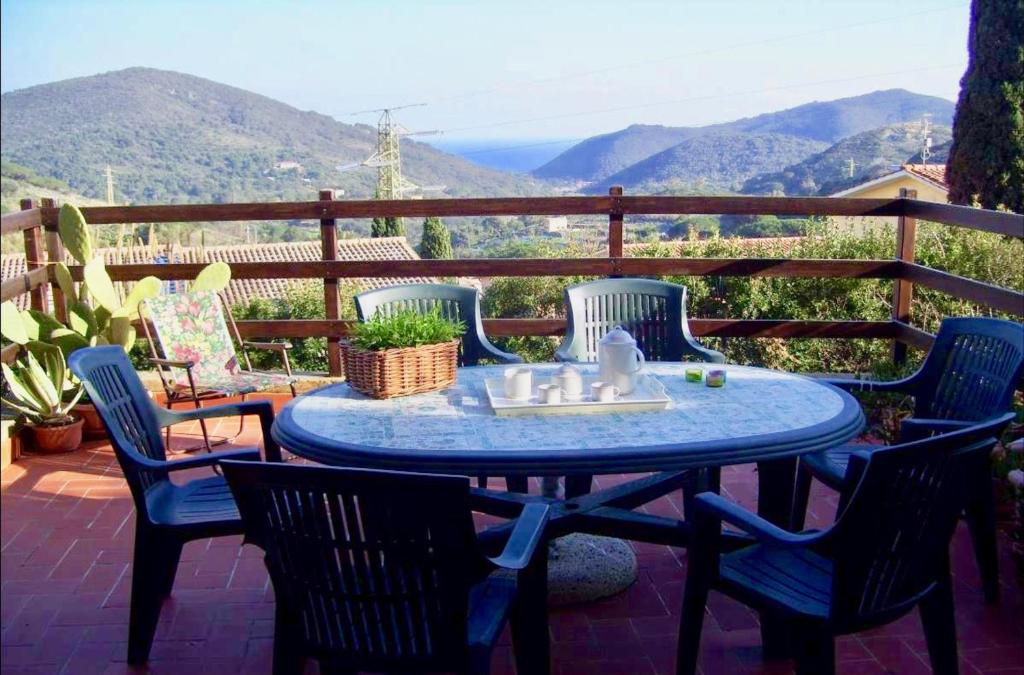 a blue table and chairs on a patio with a view at I Sentieri in Rio nellʼElba