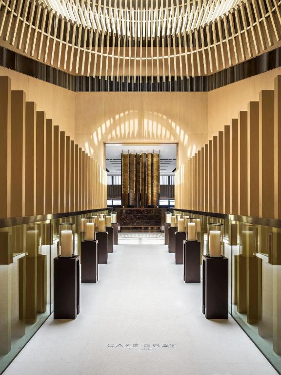 una fila di sedie in una grande stanza con lampadari a braccio di The Upper House a Hong Kong