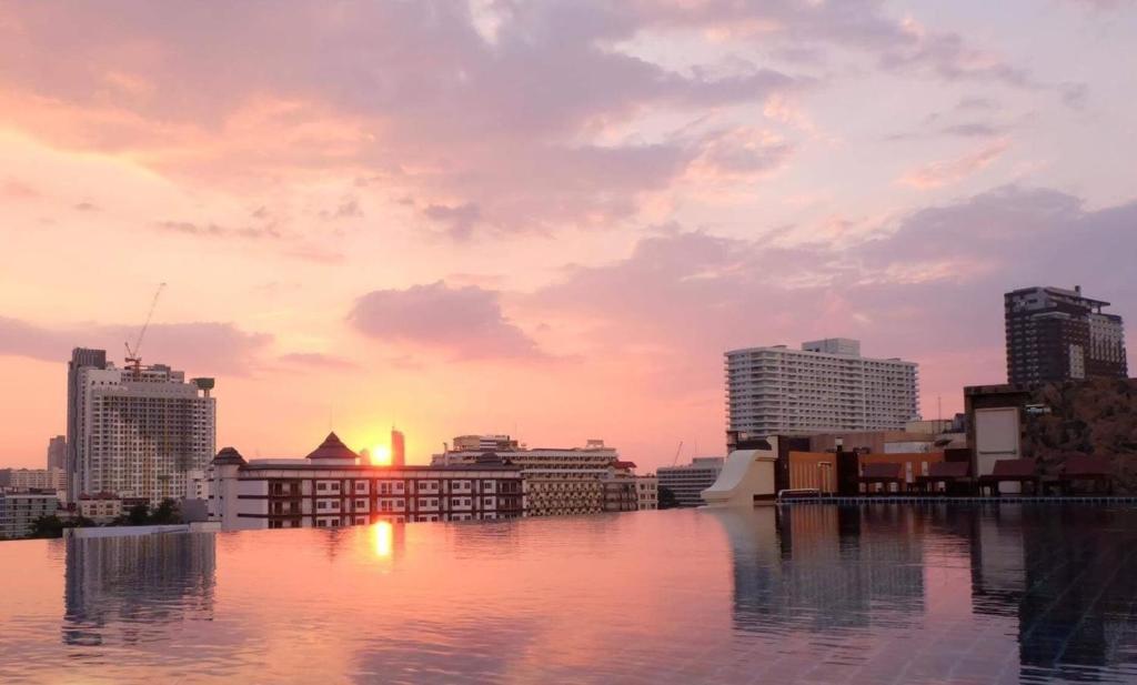 een uitzicht op de skyline van de stad bij zonsondergang bij Dhotel Pattaya in Nong Prue