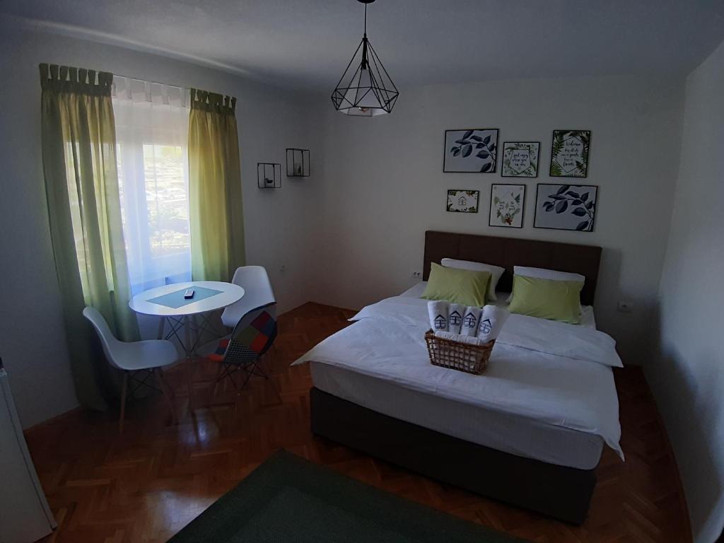 a bedroom with a bed and a table and chairs at Brana Gorica Apartments in Trebinje