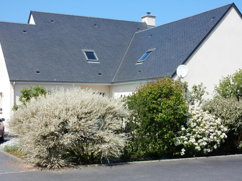 une maison avec des buissons à fleurs devant elle dans l'établissement Cador'shouse, à Vaucelles