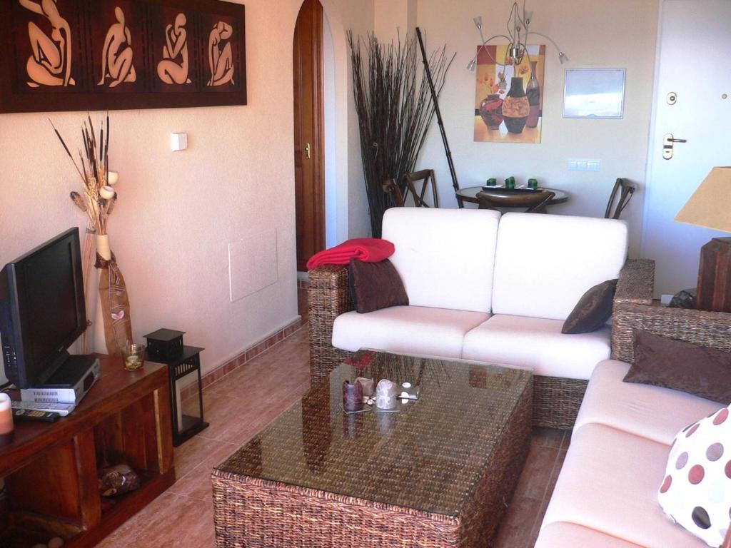 A television and/or entertainment centre at Miradores Del Puerto One Bedroom Apartment RP019