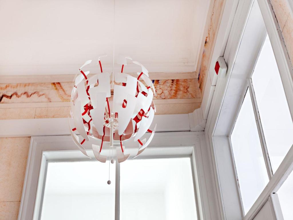 a large white chandelier hanging from a ceiling at Baixa Terrace Hostel in Faro