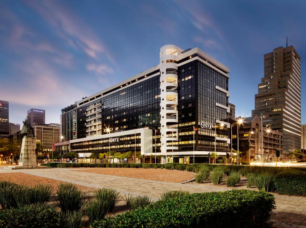 a large building in a city at night at The Onyx Apartment Hotel by NEWMARK in Cape Town