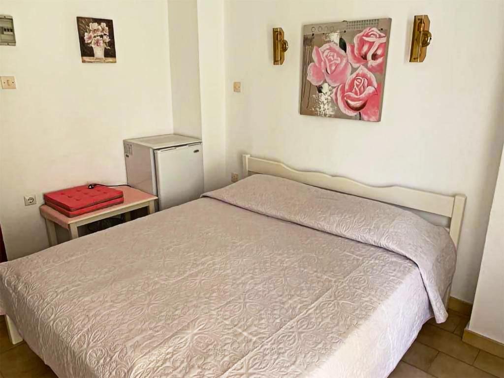 sypialnia z łóżkiem i stołem z czerwoną walizką w obiekcie Sunshine Pension w mieście Pitagorio