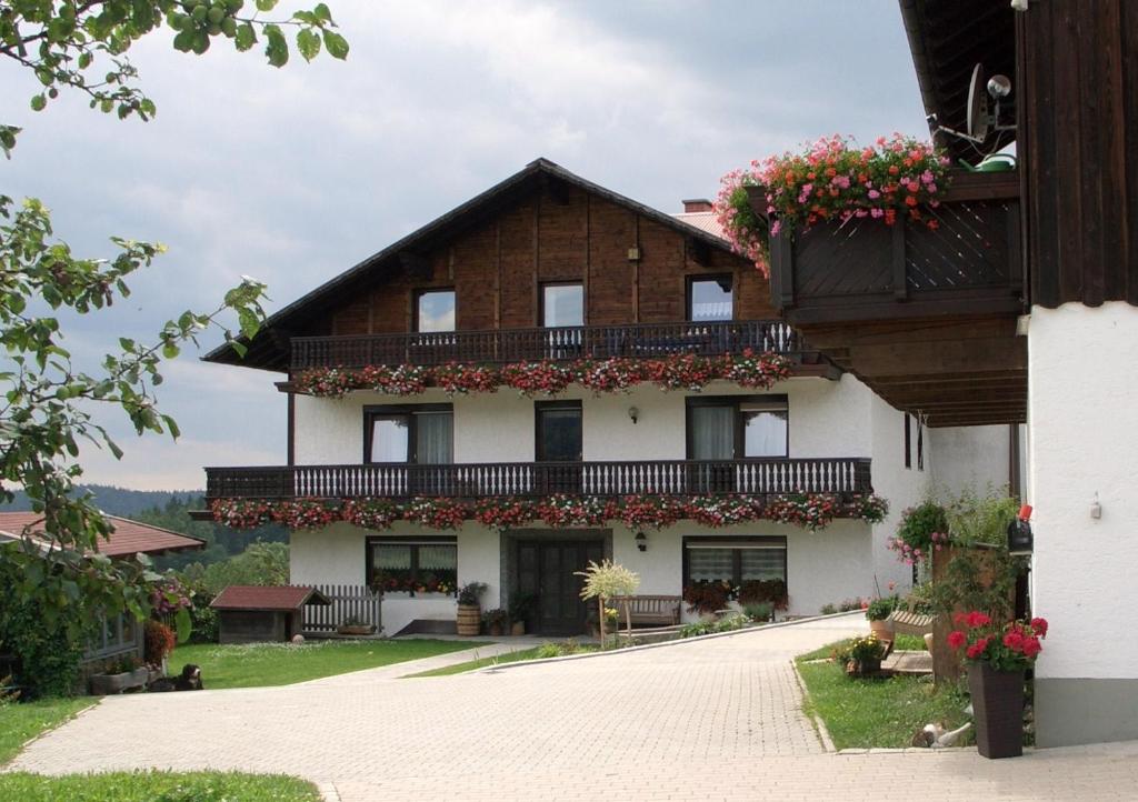 - un bâtiment avec un balcon fleuri dans l'établissement Stoahauerhof, à Grainet