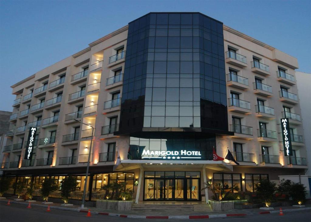 a large hotel with a sign on the front of it at Marigold Hotel in Tunis