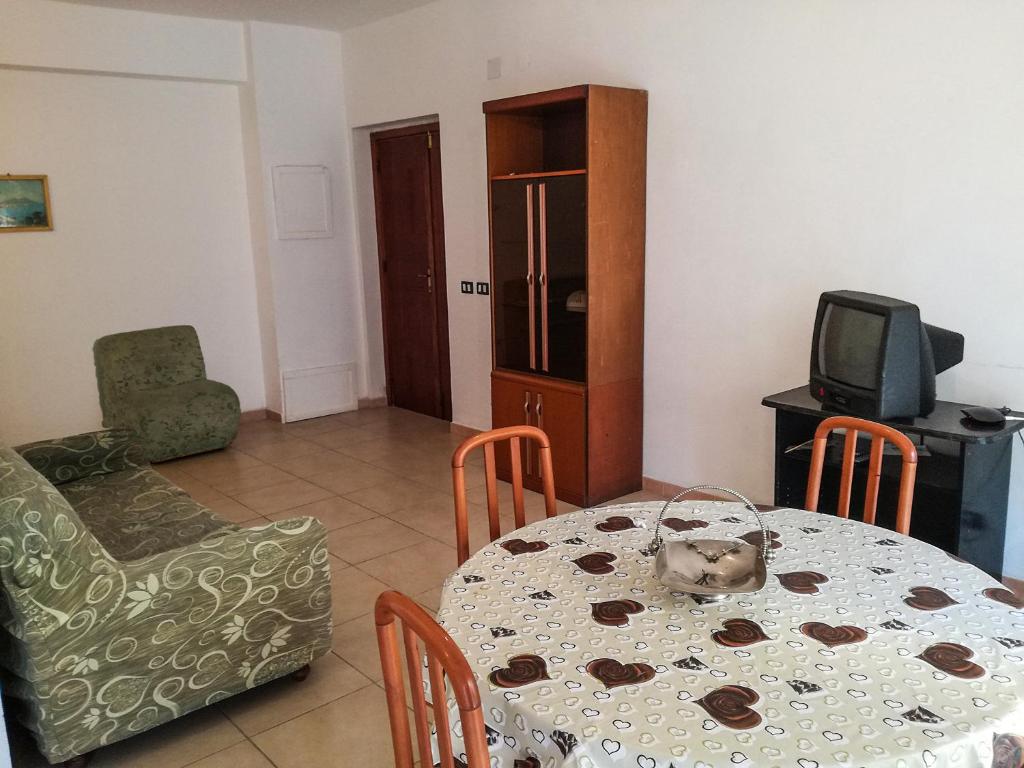 comedor con mesa, sillas y TV en Appartamento a Villapiana Lido, en Villapiana