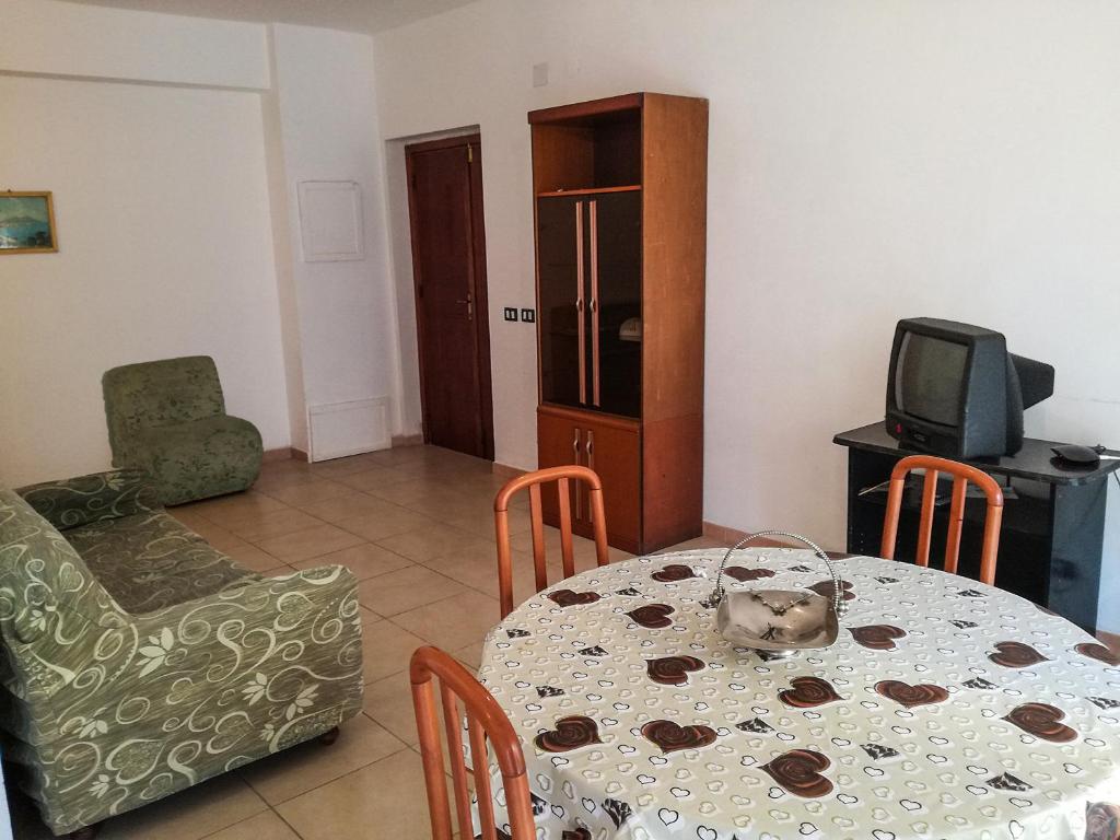 a dining room with a table and chairs and a television at Appartamento a Villapiana Lido in Villapiana