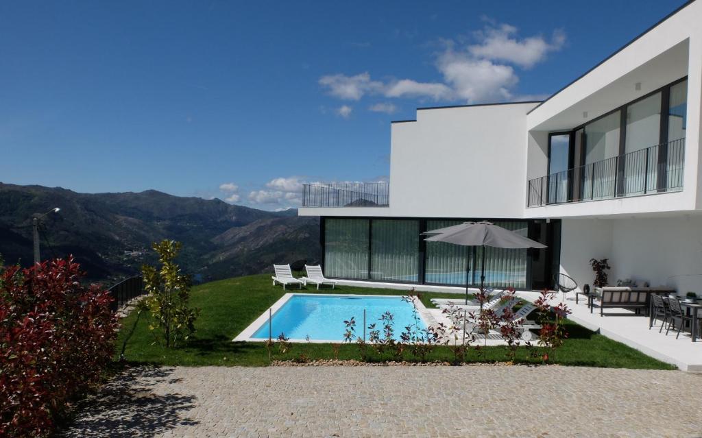 a house with a swimming pool and a table and chairs at Casa de S. Brás in Vieira do Minho