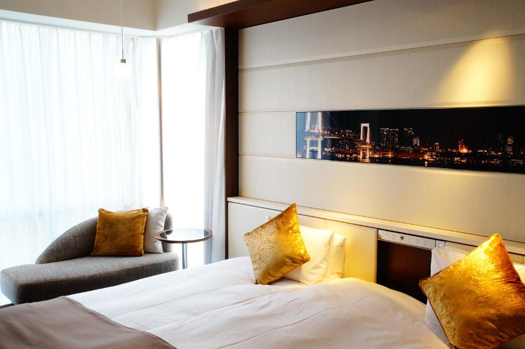 a hotel room with a bed and a chair at Solaria Nishitetsu Hotel Ginza in Tokyo