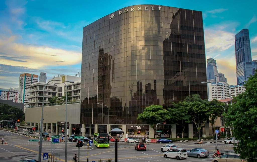 un bâtiment en verre avec un panneau sur son côté dans l'établissement Dorsett Singapore, à Singapour