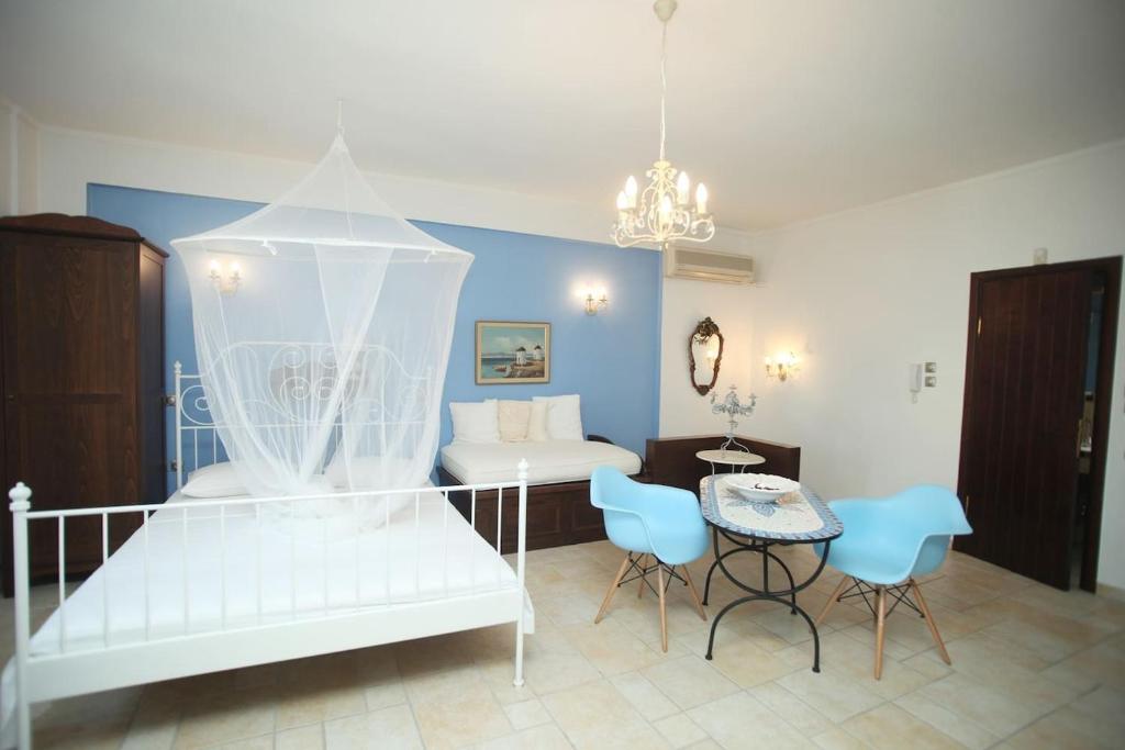 a bedroom with a white bed and a table and chairs at Beautiful Studio in traditional Afytos Halkidiki-UVC sterilized in Afitos