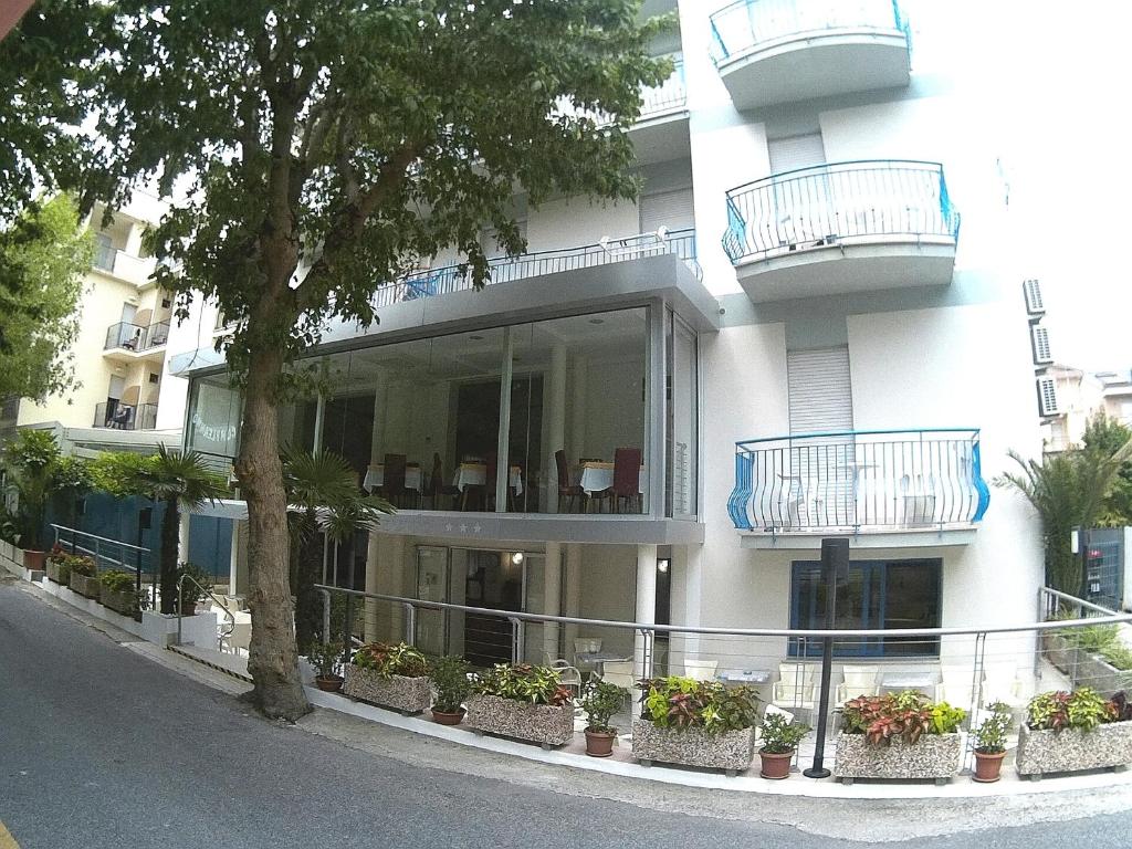 un edificio con balcones y macetas. en Hotel Azzurro, en Cattolica