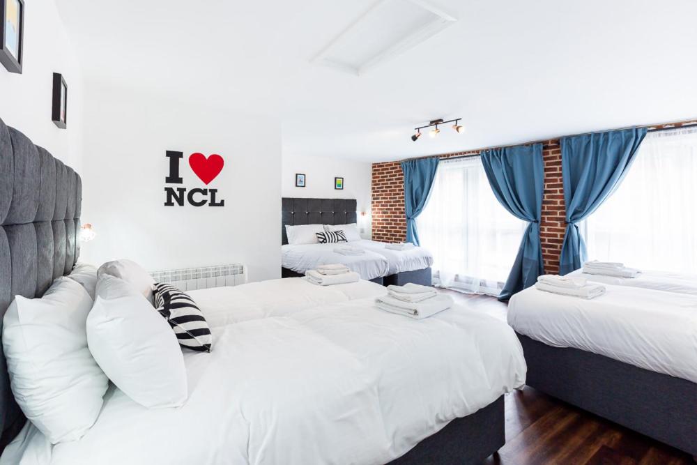 Habitación de hotel con 2 camas con sábanas blancas en Honeypot House, en Newcastle
