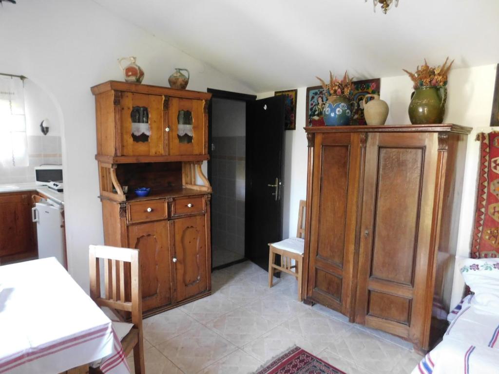 a kitchen with a large wooden cabinet in a room at Babamúzeum kis apartman in Tihany