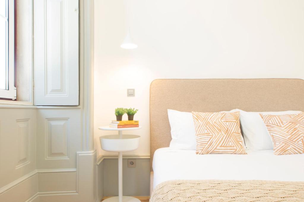 a bedroom with a bed and a table with a plant on it at Solar da República in Coimbra