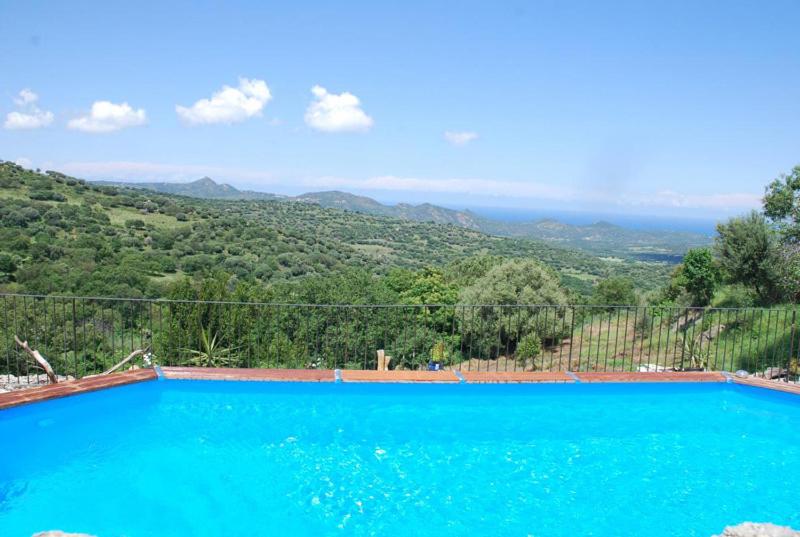 una piscina azul con vistas a la montaña en costa di sognu en Costa