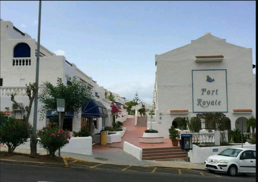 een wit gebouw met een auto ervoor geparkeerd bij Port Royale in Arona
