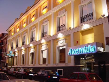 a large building with cars parked in front of it at Hotel Avenida Leganés in Leganés