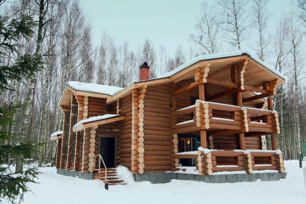 una cabaña de madera en el bosque en la nieve en Sanatoriy Serebryany Ples, en Kuzminka