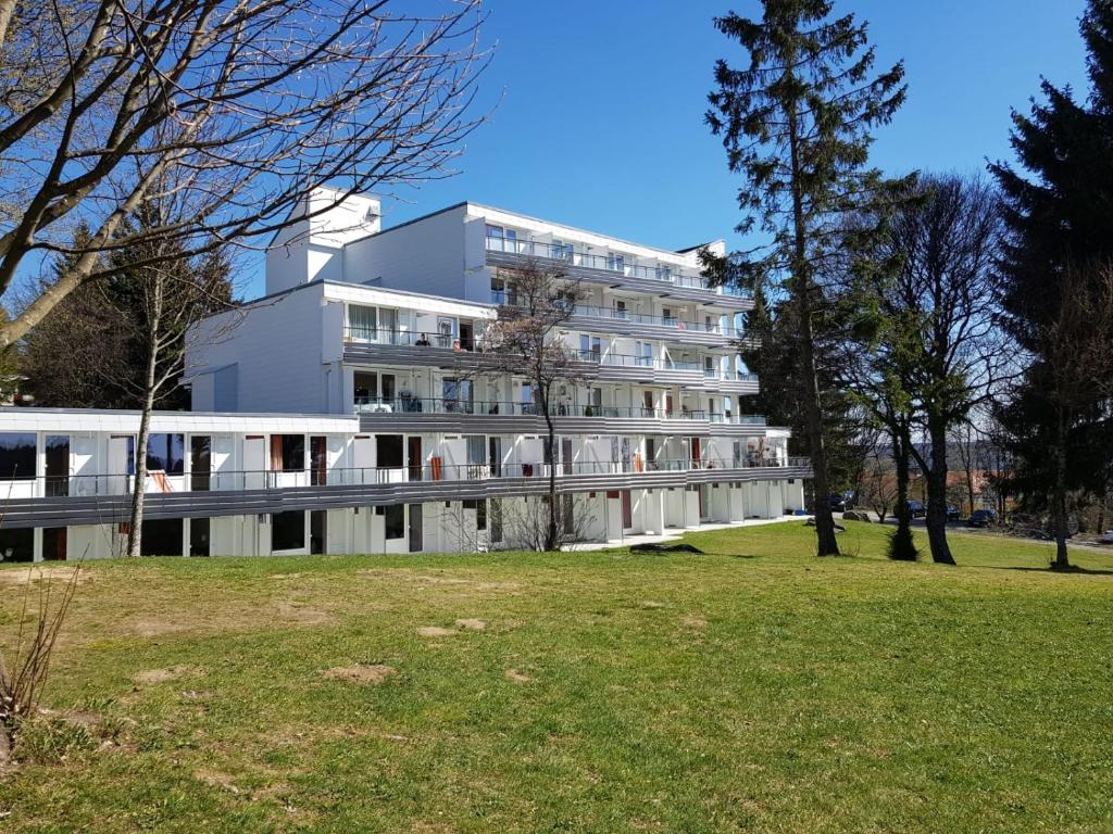 a white building with a park in front of it at Family Appartment in Sankt Englmar