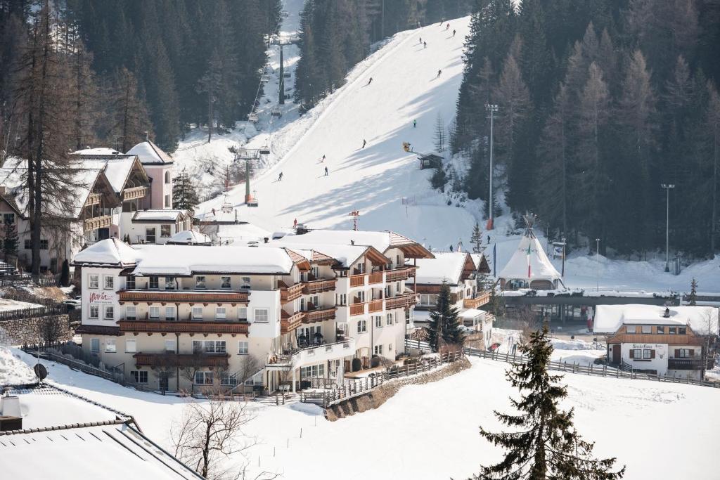 un edificio su una pista sciistica con la neve di Familienhotel Maria a Obereggen