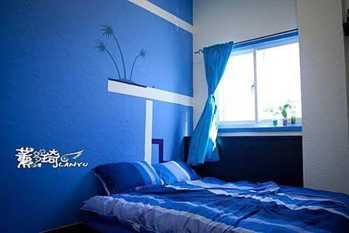 Dormitorio azul con cama y ventana en Lanyu Shundouchi Homestay, en Lanyu
