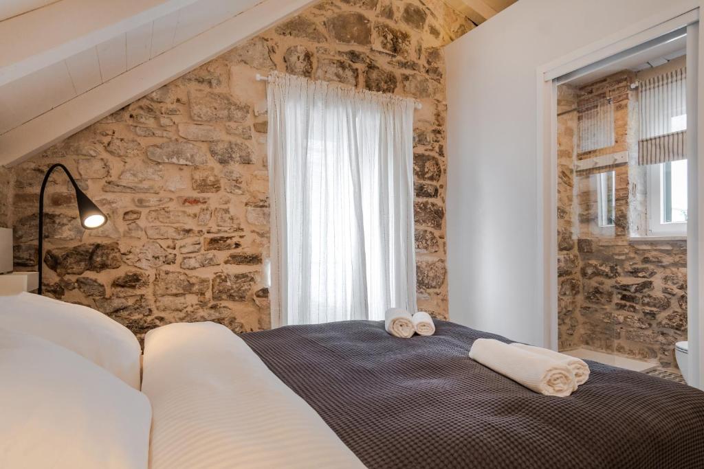 Bett in einem Zimmer mit einer Steinmauer in der Unterkunft No.5 Luxury Studio in Split