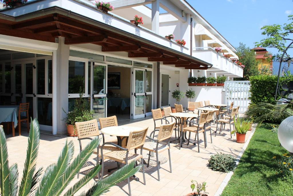 - une terrasse avec un bouquet de tables et de chaises dans l'établissement Hotel Mare Azzurro, à Terracine