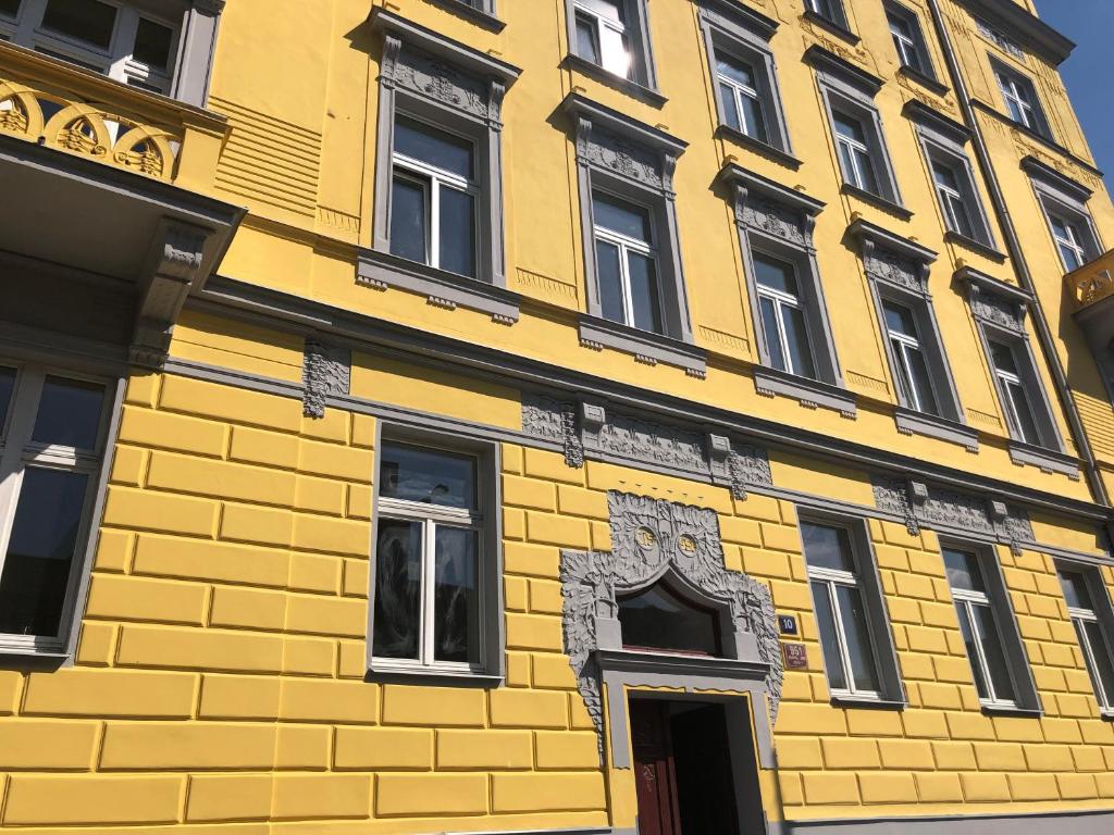 Letna Garden Suites في براغ: مبنى اصفر مع نوافذ وباب