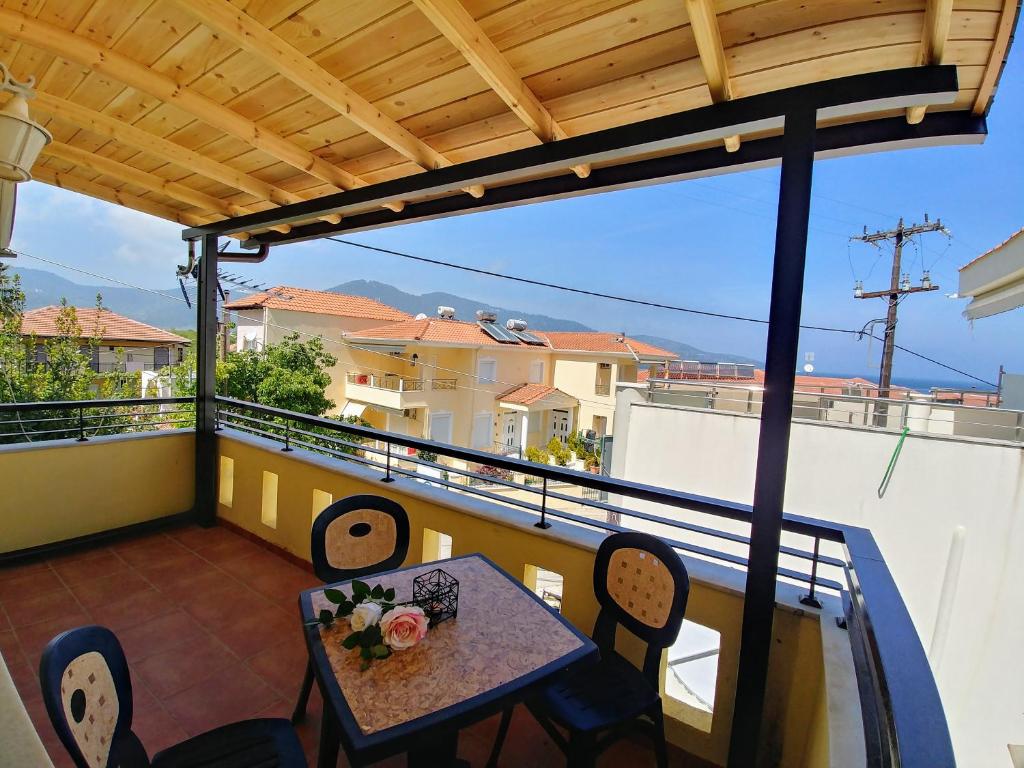 a patio with a table and chairs on a balcony at Methexis Apartment in Skala Potamias