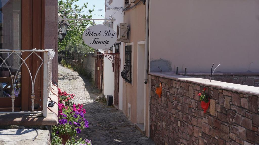 a small alley with a sign on a building at Fikretbey Konağı in Ayvalık